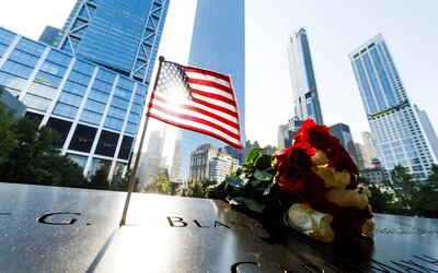Flores y una bandera estadounidense sobre los nombres de los fallecidos en los ataques del 11 de septiembre de 2001, en el monumento dedicado a ese evento en Nueva York.