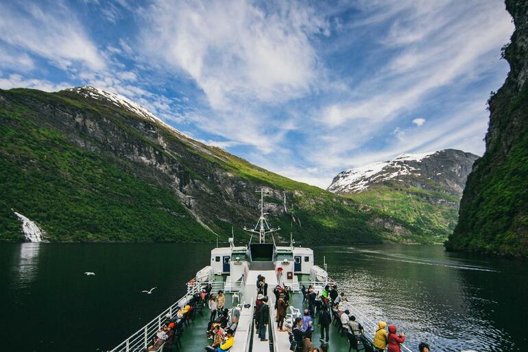 Turistas viajan en Ferry a trav&eacute;s del fiordo Geiranger en Noruega.
