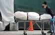 El cadáver de un paciente que falleció por coronavirus es transportado a un camión refrigerador que funciona como morgue temporaria en el Brooklyn Hospital Center en Nueva York.