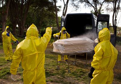 Los trabajadores del cementerio de Piura, Perú, desinfectan el ataúd de una víctima de COVID-19 el 15 de abril de 2020.