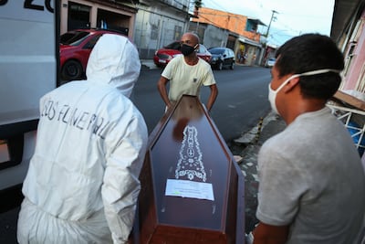 Los trabajadores municipales extraen el cuerpo de una persona sospechosa de haber muerto por COVID-19, de su hogar en Manaus, en el estado brasileño de Amazonas.