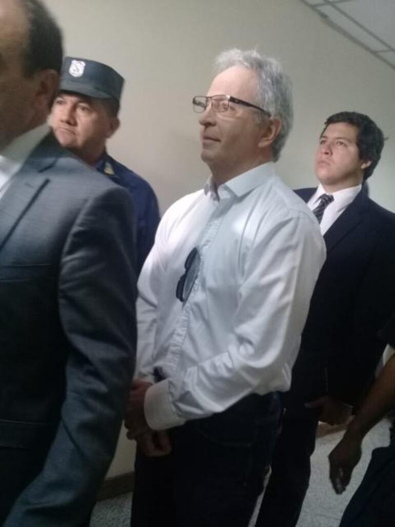 Justo Cárdenas, ocultando sus esposas debajo de su camisa.