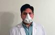 El médico mostrando una de las mascarillas de bioseguridad.