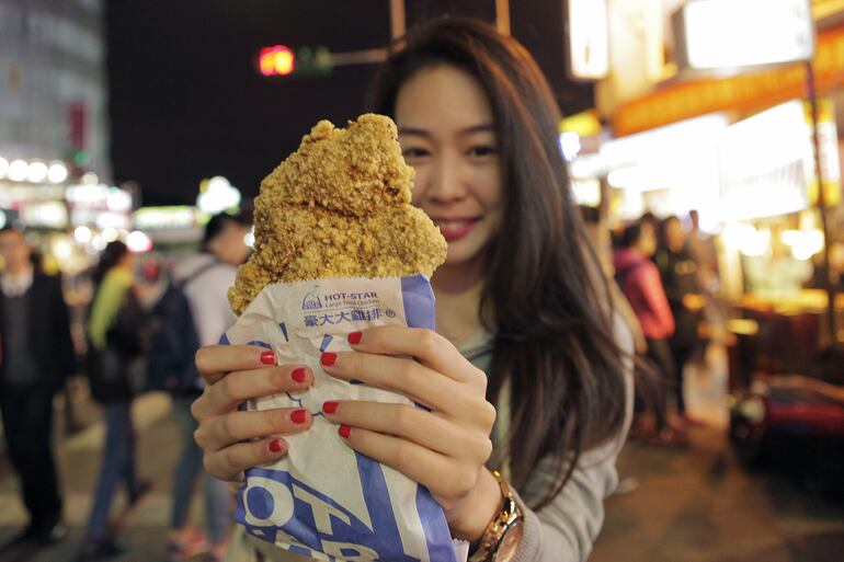 Una mujer compra pollo frito en el Shilin Night Market de Taipei.