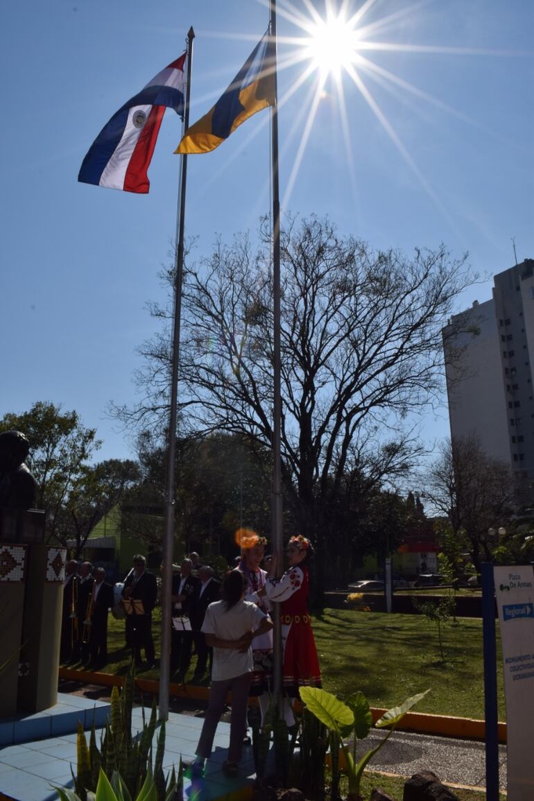 Dos niñas ataviadas con trajes típicos ucranianos izan la bandera Ucraniana.