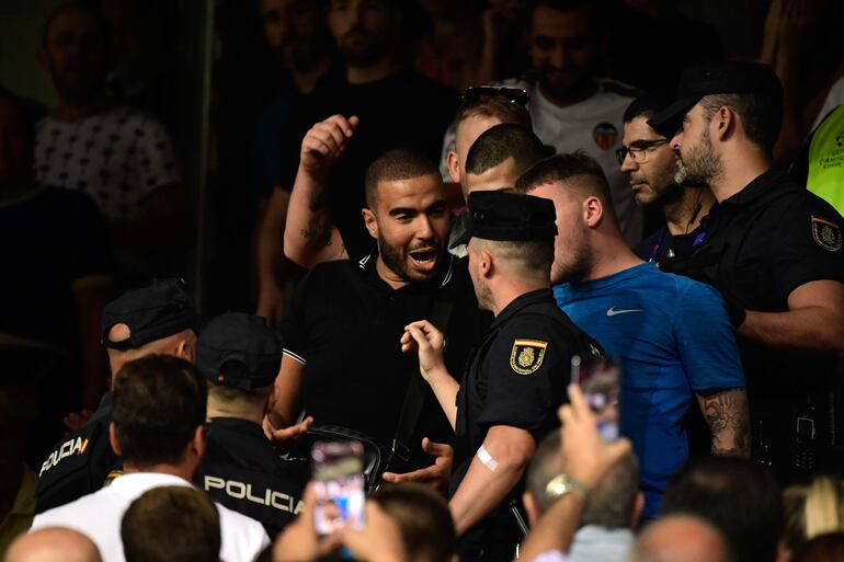 Policías españoles se acerca a los aficionados del Ajax para sacarlos del estadio de Mestalla.