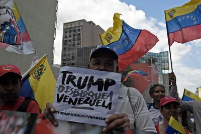 Un manifestante chavista sostiene un cartel que reza "Trump desbloquea Venezuela" durante la marcha de este miércoles en Caracas.