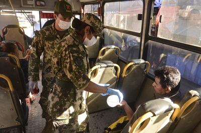 Militares subían ayer a los buses urbanos a distribuir alcohol en gel entre quienes debieron salir de sus casas.