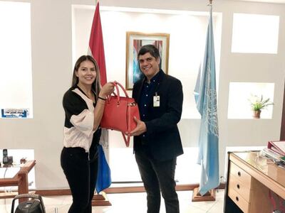 El subcomisario Oliver Fernández hace entrega de la cartera recuperada a su propietaria, Patricia Alderete.