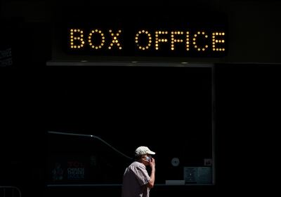 Un hombre camina frente a la taquilla cerrada del Teatro Chino de Hollywood, California.