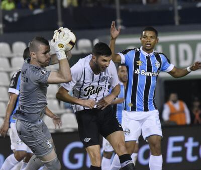 El arquero brasileño Paulo Víctor captura el balón ante la presencia de Adrián Martínez, en uno de los ataques de Libertad.