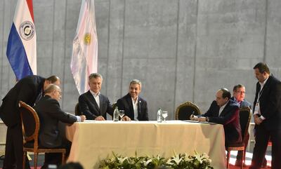 Los presidentes Mauricio Macri (c) y Mario Abdo observan la firma de los cancilleres, que oficializa el paso entre Ayolas e Ituzaingó.