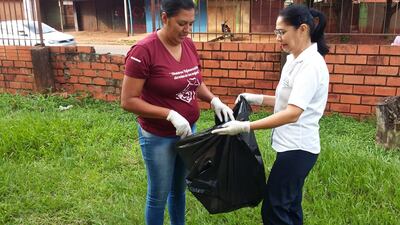 Funcionarias del Ministerio de Salud ayudan en la colección de basuras como parte de una limpieza para evitar la proliferación de criaderos.