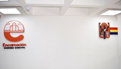 El logo (izq.) establecido por el intendente Luis Yd y el escudo municipal (der.), en la nueva sede comunal de Encarnación.