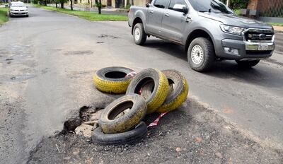 La misma calle dañada casi en su totalidad, también está ingeniosamente “señalizada” por la iniciativa ciudadana. Colocan neumáticos viejos para avisar a los conductores.