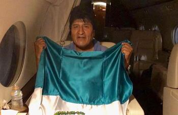 Evo Morales con la bandera de México cuando abordó la aeronave.