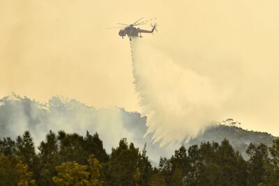 Un helicóptero arroja agua sobre una zona en llamas en Batemans Bay, en el estado australiano de Nueva Gales del Sur, este martes.