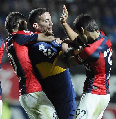 Al más puro estilo MMA, Óscar Romero le toma del cuello de Iván Marcone,
 de Boca Juniors, mientras que su hermano Ángel se suma para ayudarlo.