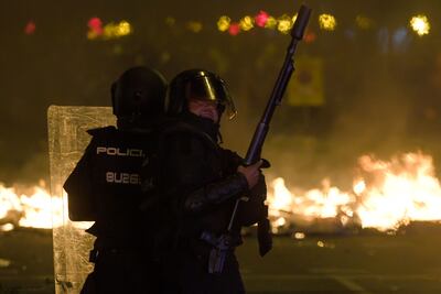 Policías antidisturbios se enfrentan a manifestantes en Barcelona, este martes.