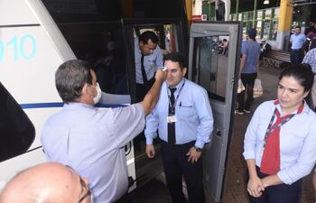 Autoridades controlan la temperatura a choferes y pasajeros en la Terminal de Ómnibus de Asunción.