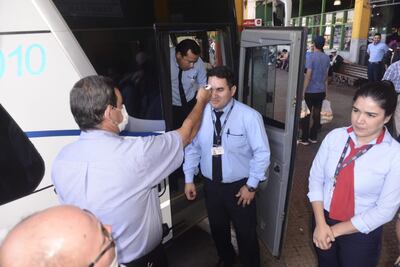 Autoridades controlan la temperatura a choferes y pasajeros en la Terminal de Ómnibus de Asunción.