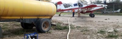 Desde un cisterna reabastecen el tanque de agua del avión tanque AT 802 cedido por Chile para sofocar los incendios en el Chaco.