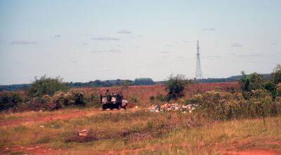 Una camioneta repleta de vegetales se dirige hacia Aba’i. Al costado de la vía se nota  un basural.