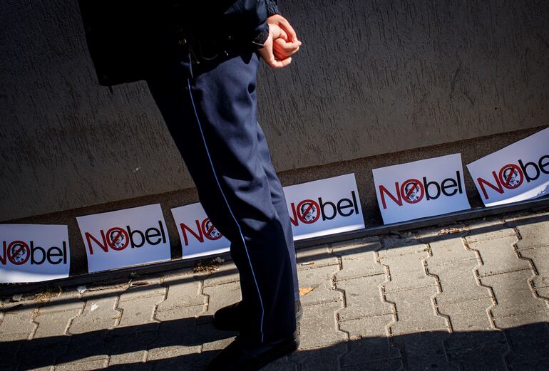 Un policía de Kosovo custodia el área donde han colocado pancartas en contra del Premio Nobel de Literatura 2019.