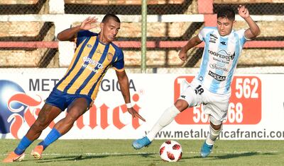 El delantero Antonio Marín, de Guaireña, intenta escapar del zaguero auriazul Jorge Paredes, con la pelota a sus pies. En juego discreto empataron Sportivo Luqueño y el conjunto del Guairá a un gol por sector y siguen con mucho por corregir.