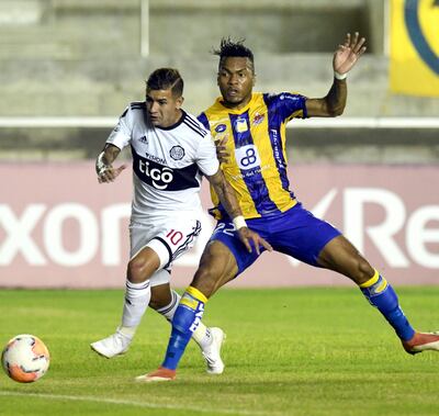Derlis González escapa con la pelota de la marca del defensor ecuatoriano Luis Cangá, quien había hecho el gol en contra para Olimpia a los cinco minutos del encuentro.