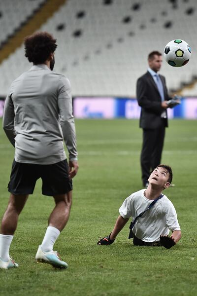 Mohamed Salah juega al balón con un niño discapacitado, en el campo del Besiktas, donde hoy enfrentarán al Chelsea.