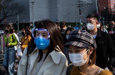 Personas con mascarillas cruzan una calle en Pekín, China.