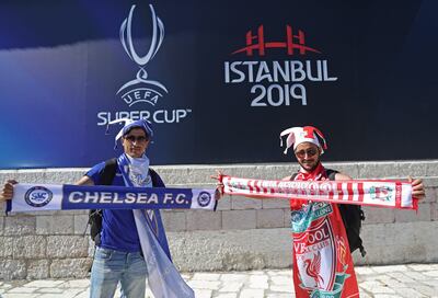 Fanáticos de ambos equipos posan con sus colores en las afueras del estadio.