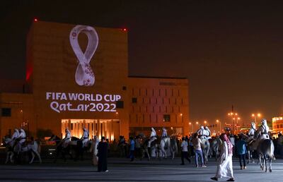 Los qataríes se reúnen en el mercado tradicional Souq Waqif de Doha, la capital, mientras el logotipo oficial de la Copa Mundial de la FIFA Qatar 2022 se proyecta en el frente de un edificio el 3 de septiembre de 2019.