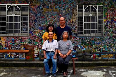 El artista de graffiti hakka Wu Tsun-hsien (arriba, der.) posando con su familia frente a su casa en el pueblo taiwanés de Ruan Chiao.