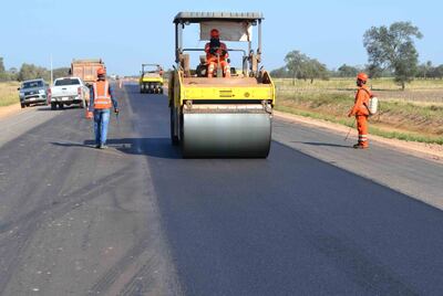 Obreros  colocan la  capa asfáltica final, lado derecho, del corredor bioceánico.