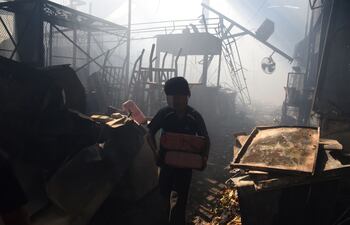 un-nino-intenta-salvar-mercaderias-mientras-el-fuego-y-el-humo-siguen-en-el-bloque-c--195547000000-1640270.jpg