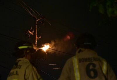 Bomberos de Mariano Roque Alonso observan sin poder hacer mucho a que un transformador de la ANDE termine de consumirse.