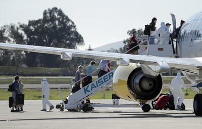 Pasajeros del crucero Grand Princess que estuvo 5 días varado en la costa californiana a causa de contagios con coronavirus reciben ayuda para abordar un avión chárter en  Oakland.