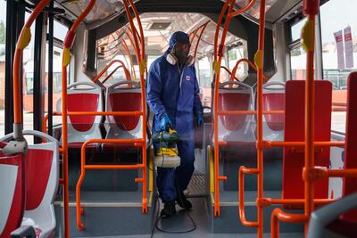 Un trabajador del municipio de Burgos desinfecta un bus de transporte público.