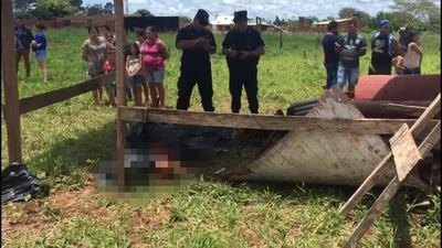 Agentes policiales y curiosos alrededor del sitio donde fue hallado el cuerpo de Bruno Patiño Torales, este domingo en Pedro Juan Caballero.