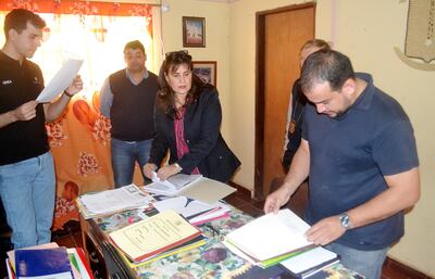 La fiscala Victoria Acuña en el momento de verificar documentaciones y presentar al intendente Sergio Cuéllar (ANR) la orden de allanamiento.