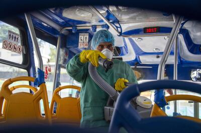 Un trabajador desinfecta un bus como medida de prevención contra el coronavirus en Quito.