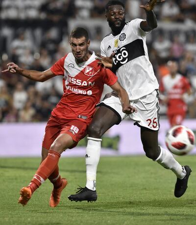 La figura de la que el hincha franjeado esperaba más.   Adebayor, en dura puja por la pelota con Richard Fernández, uno más pequeño.
