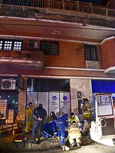 Bomberos y paramédicos brindan los primeros auxilio a Dora Esther Ramos García, en el sitio donde cayó sobre el pavimento.