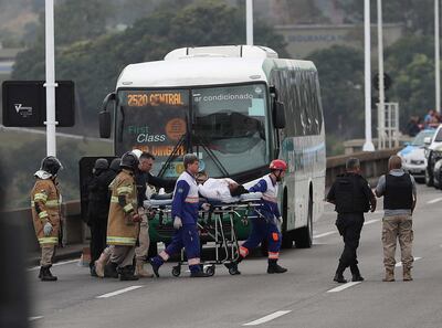 Una rehén es atendida por personal sanitario tras ser libertada por el secuestrador que la retenía en un autobús este martes en el puente Rio-Niterói. Un individuo enmascarado, armado y con gasolina, mantiene este martes como rehenes a los pasajeros y al conductor de un autobús en la ciudad brasileña de Río de Janeiro, a los que amenaza con incendiar el vehículo automotor desde su interior.