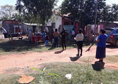 Pobladores del territorio social Virgen de Fátima del distrito de Coronel Oviedo forman fila con el debido distanciamiento sanitario para retirar el alimento de la olla popular.