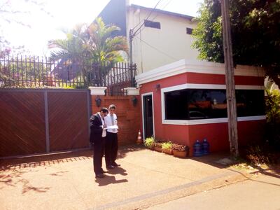 Javier Miranda, jefe de la División de Fiscalización, y otro funcionario municipal notifican al senador Javier Zacarías (ANR) para que despeje la vereda ocupada por un puesto de vigilancia.