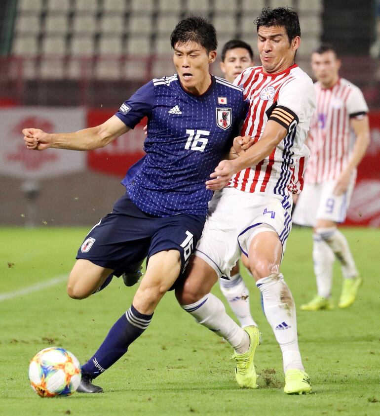 El defensor Fabián Balbuena se colocó ayer el brazalete de capitán y en esta sale a marcar a Kehiro Tomiyasu.