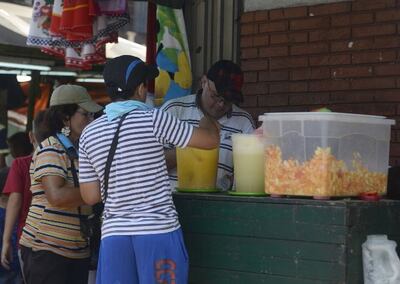 Personas compran jugo y ensalada de frutas de un puesto callejero (foto ilustrativa). La ola de calor persistirá por lo menos hasta el próximo lunes.